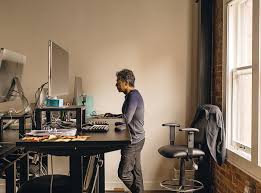 A person working at a standing desk in a bright office